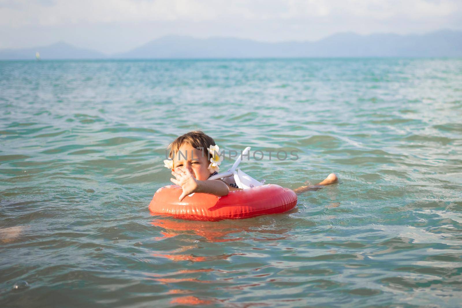 adorable toddler toddler swim in the sea in a special inflatable life ring