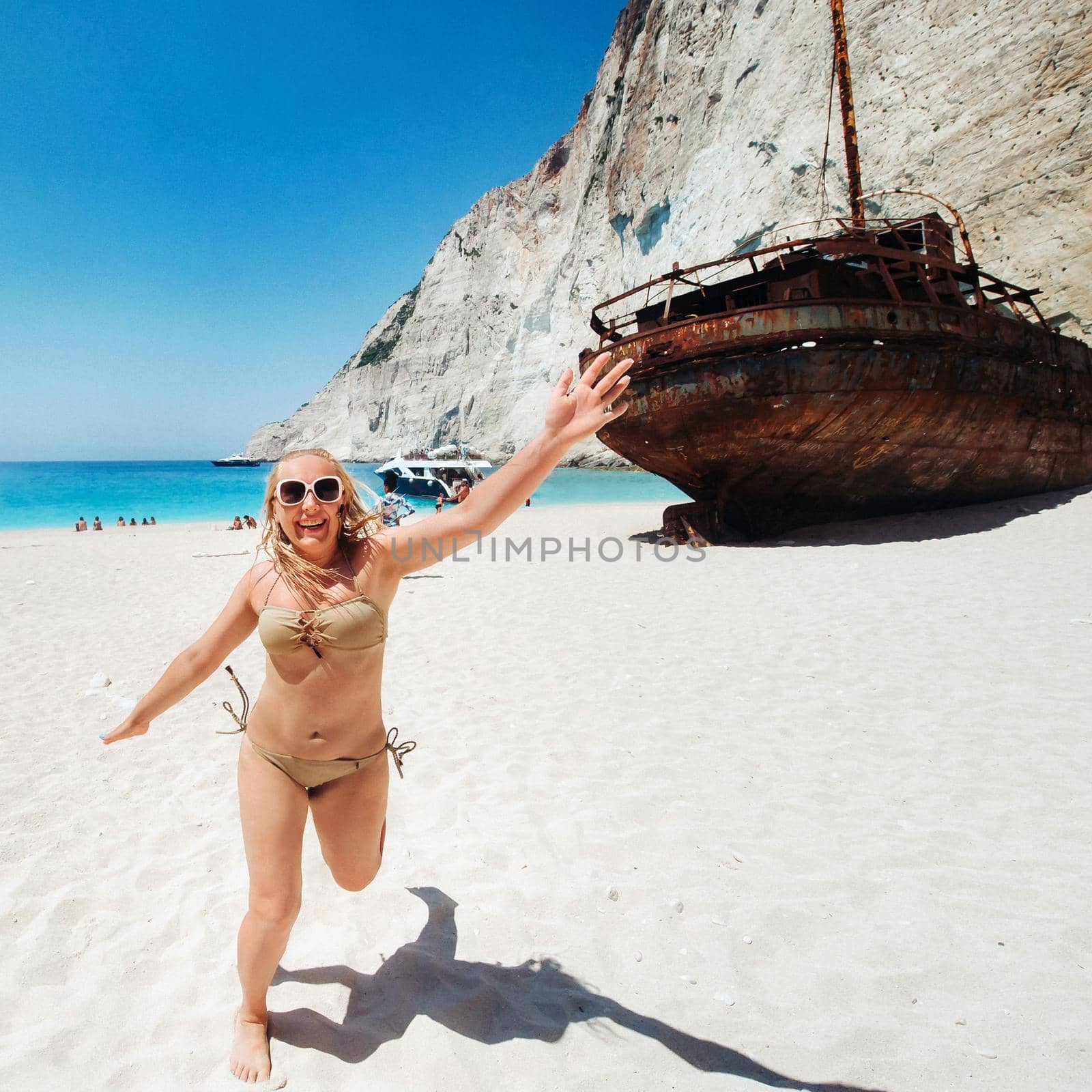 Woman relaxing on the famous Shipwreck Navagio beach in Zakynthos Greece. by Lobachad