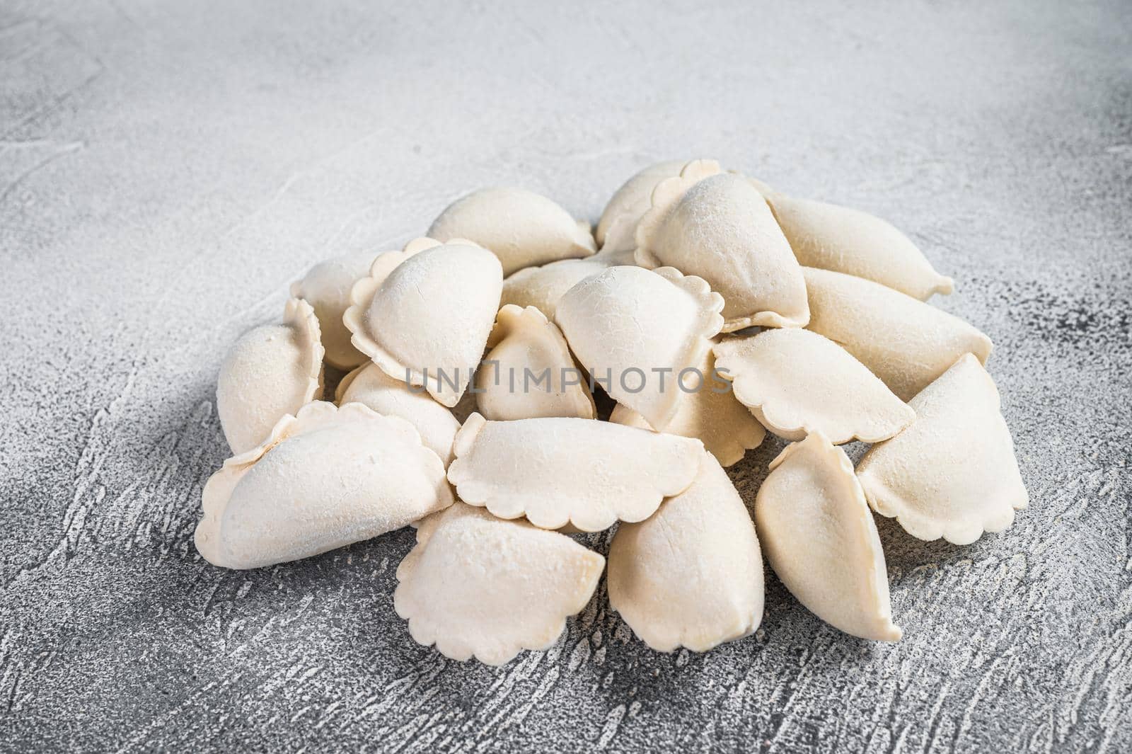 Raw frozen dumplings pierogi on a kitchen table. White background. Top View by Composter
