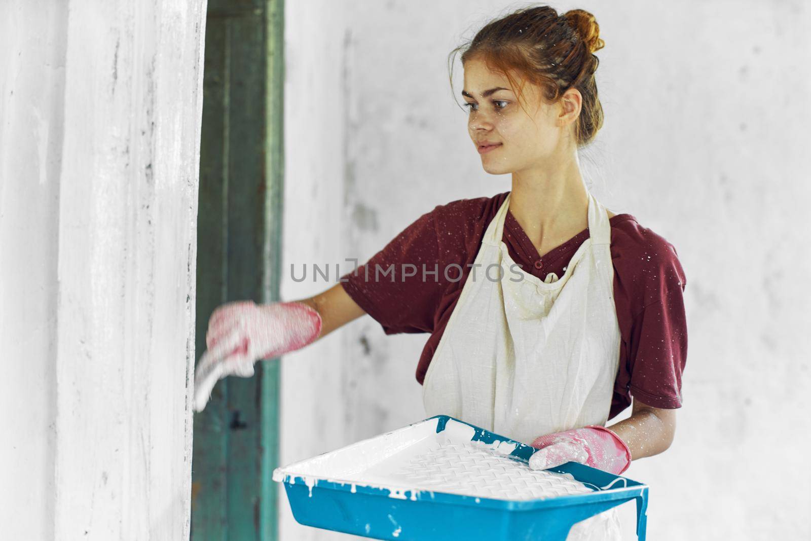 cheerful woman painter In a white apron home renovation. High quality photo