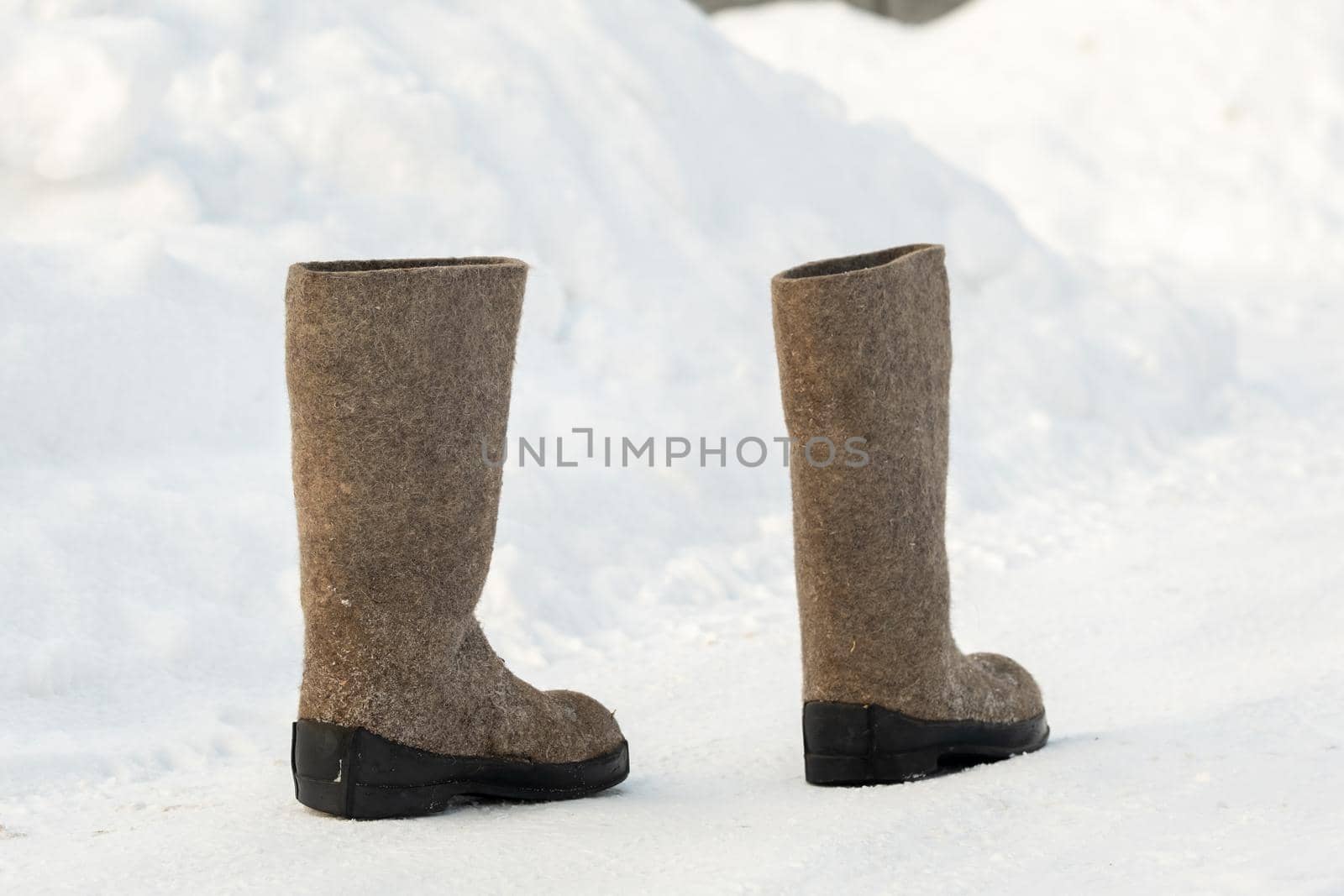 close up of felt boots standing in the snow.