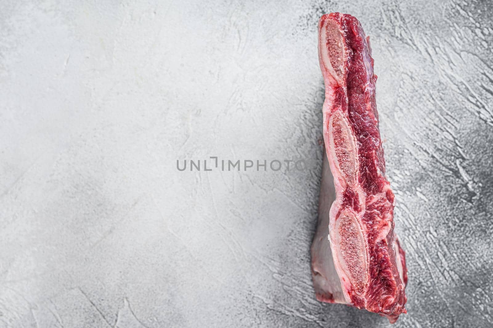 Raw beef short ribs kalbi on kitchen table. White background. Top view. Copy space by Composter