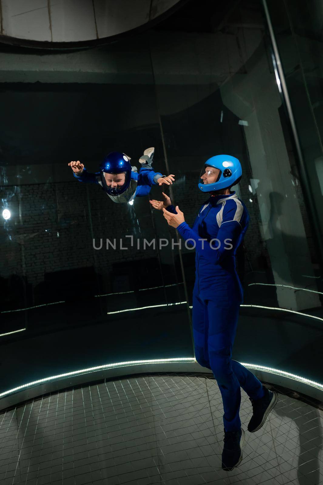 A man teaches a boy to fly in a wind tunnel. Lack of gravity. by mrwed54