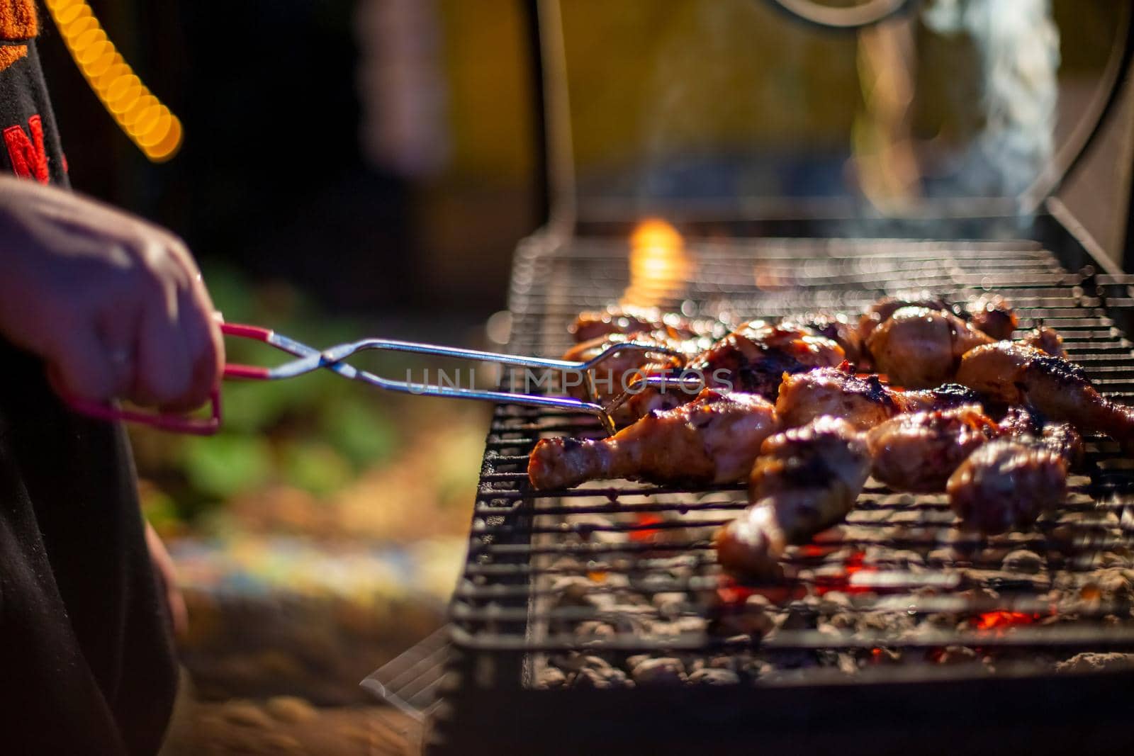 Chef cooking jerk barbecue BBQ chicken on the grill hand turning food. grilled meat
