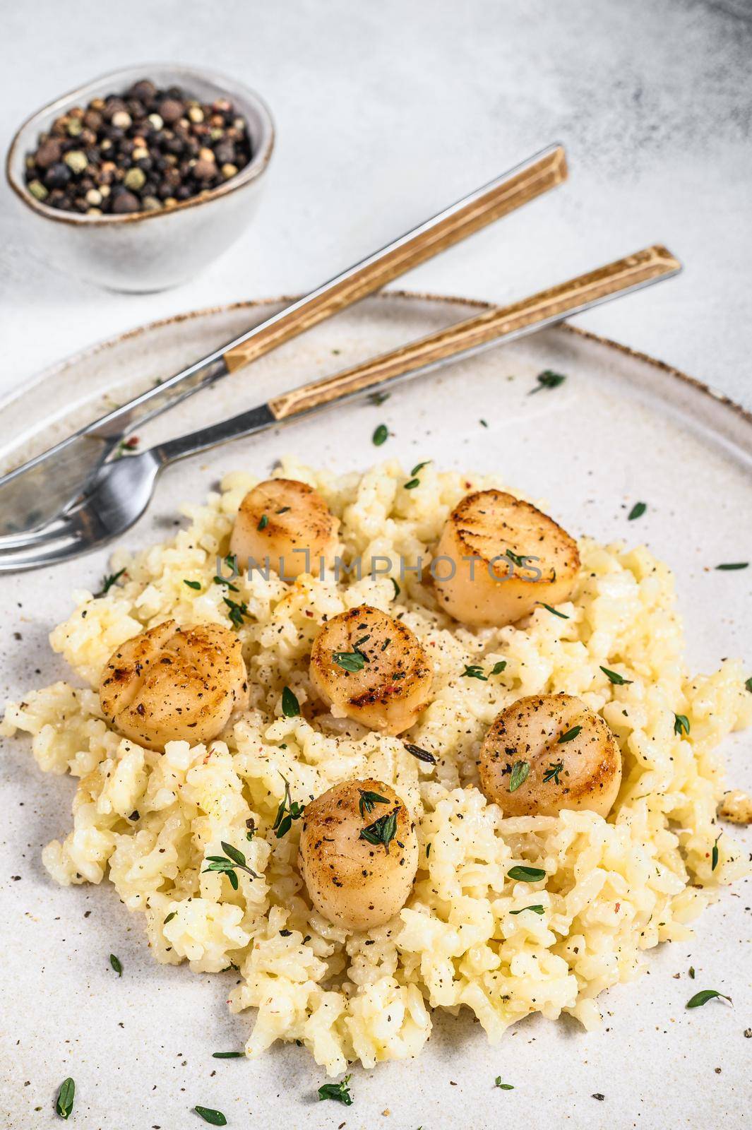 Italian Risotto with pan seared sea scallops. White background. Top view by Composter