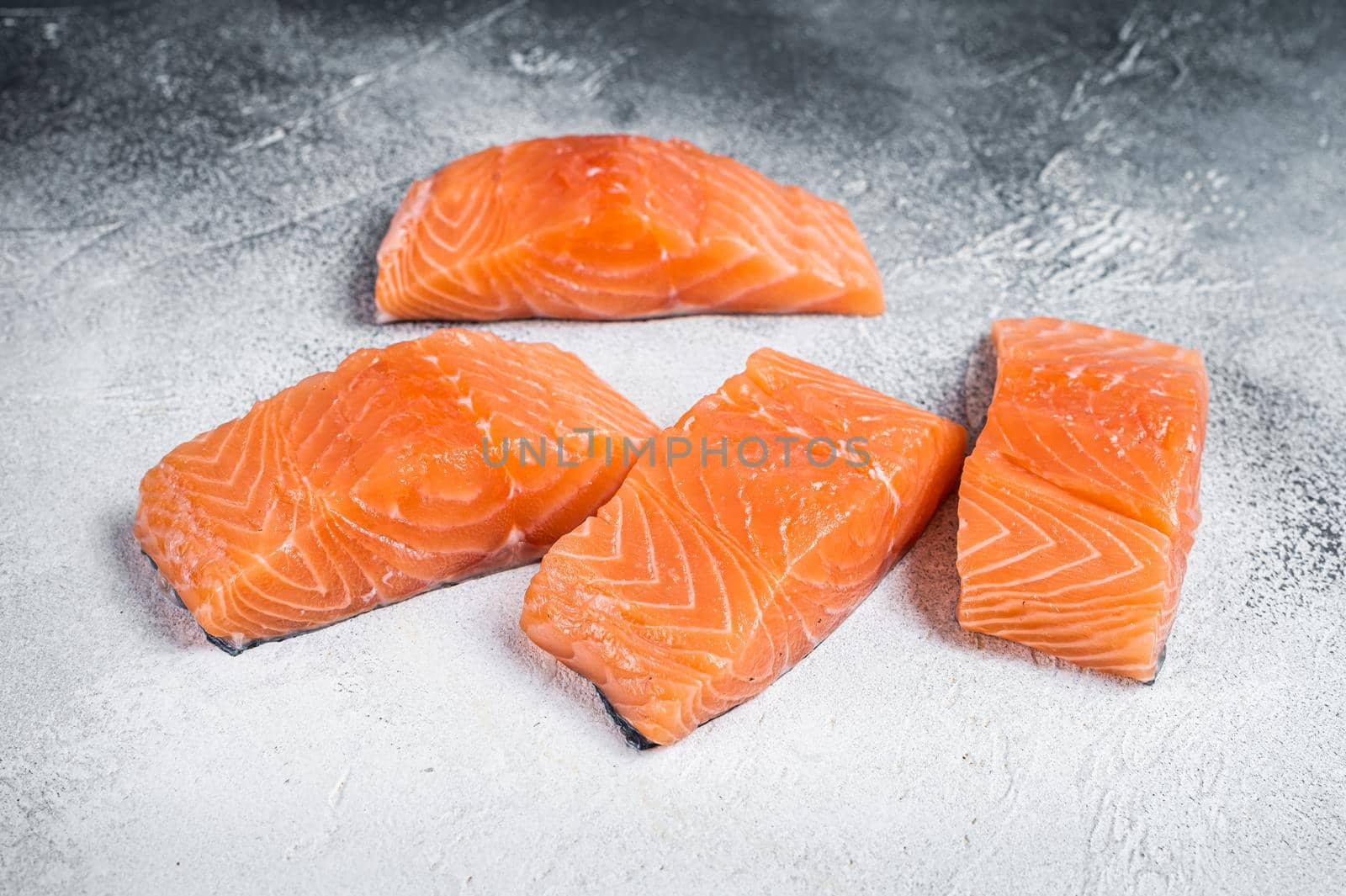 Raw salmon fillet steak on kitchen table. White background. Top view by Composter
