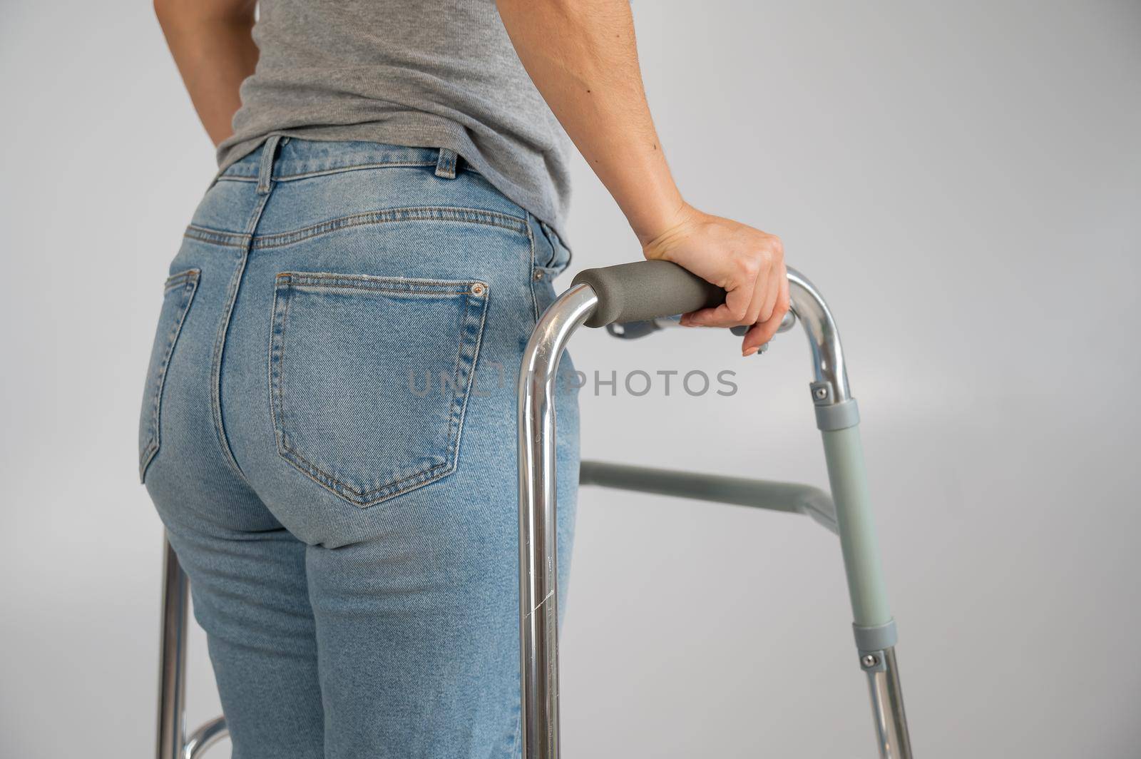 A woman is walking with a walker on a white background.