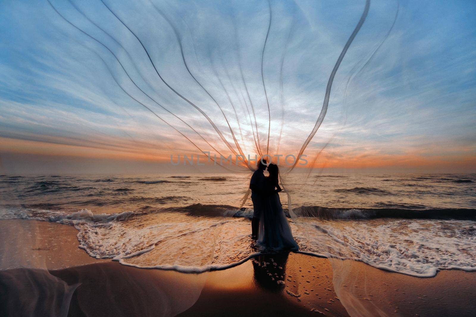 unrecognizable Silhouettes of a couple in Love at sunset against the background of the sea, an unrecognizable couple portrait of a beautiful newlywed couple expecting a child. Photo, by Lobachad