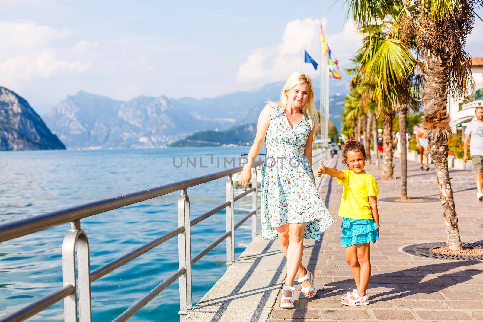 happy young mother with little daughter near sea, mother and daughter near the sea of italy.