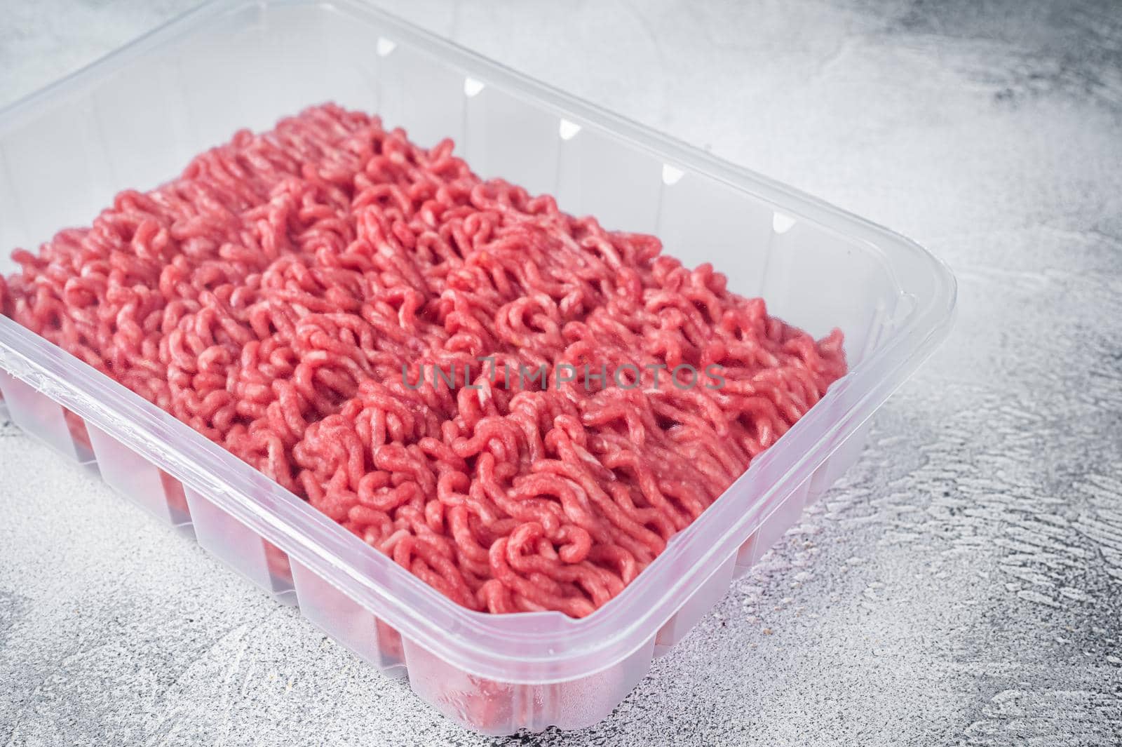 Fresh Raw mince beef and pork meat in vacuum packaging. White background. Top view by Composter