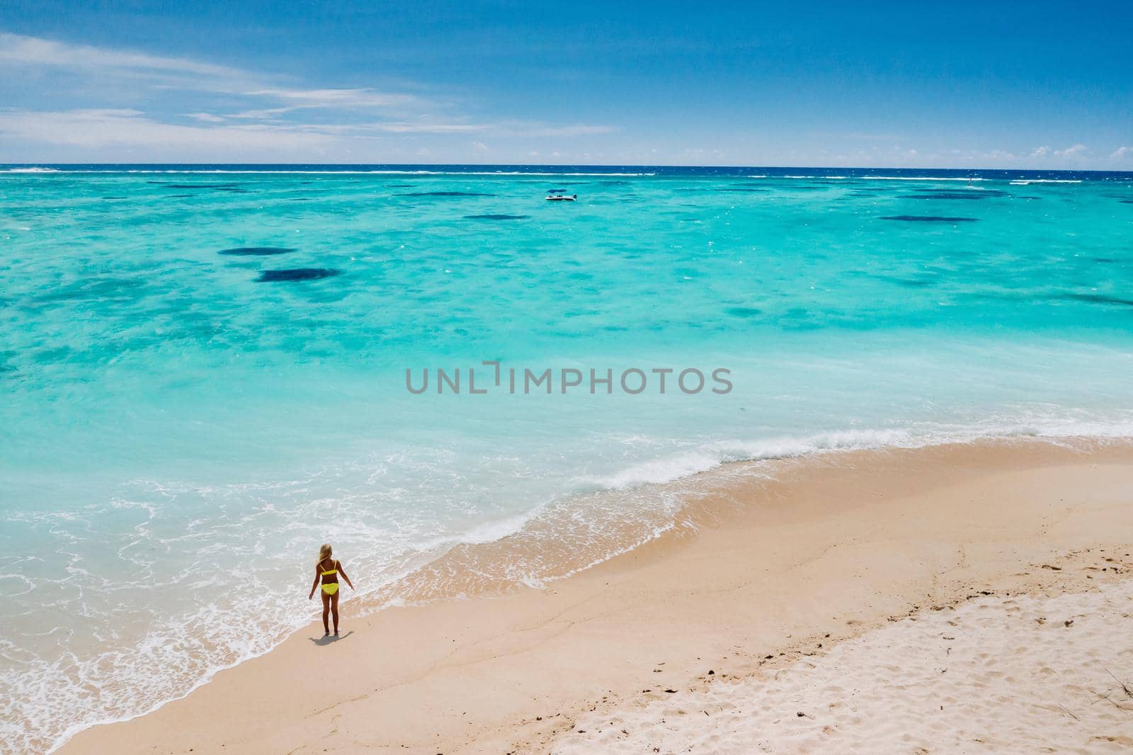 Mauritius, Indian Ocean - portrait of a girl walking along the beach with tourists from all over the world visiting the paradise island of Mauritius. by Lobachad