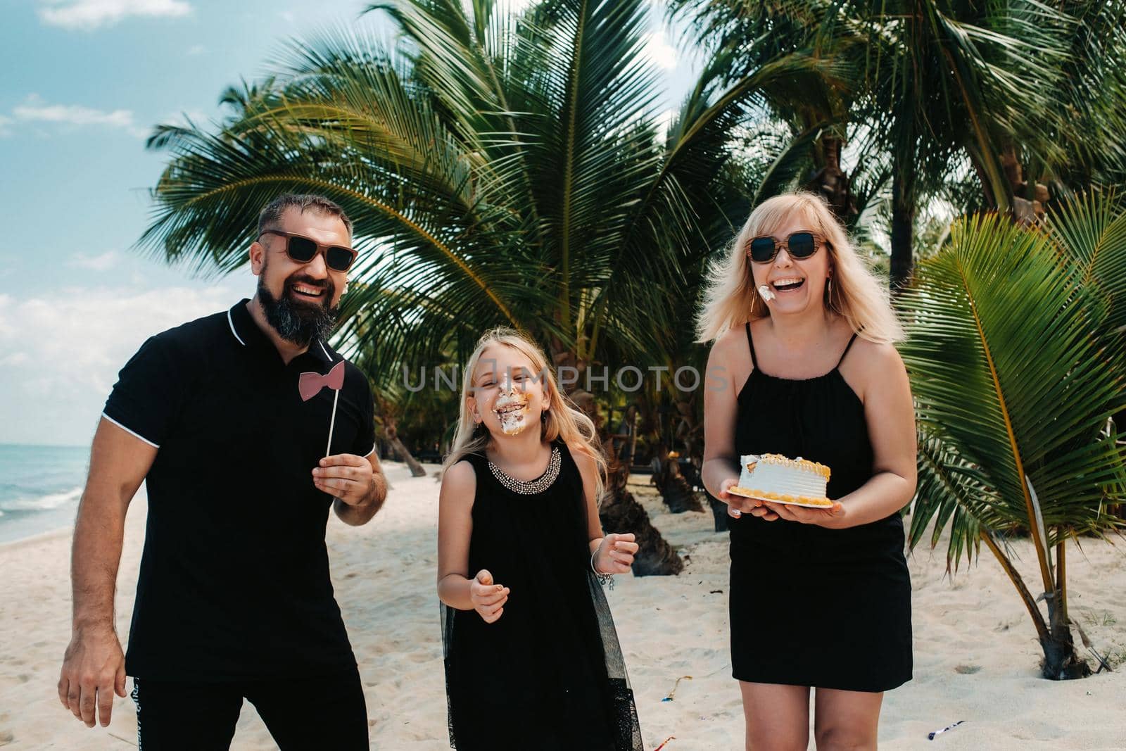 Happy beautiful family on a tropical beach celebrates the birth of their daughter.Family celebrates birthday on the island of Mauritius.