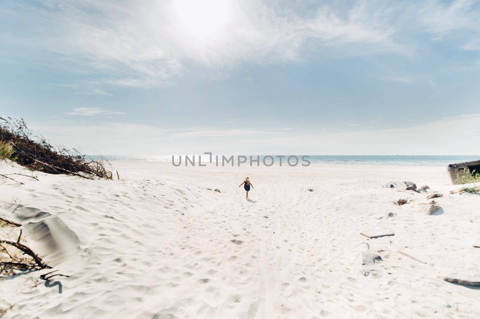 the child runs along the white beach along the Baltic Sea