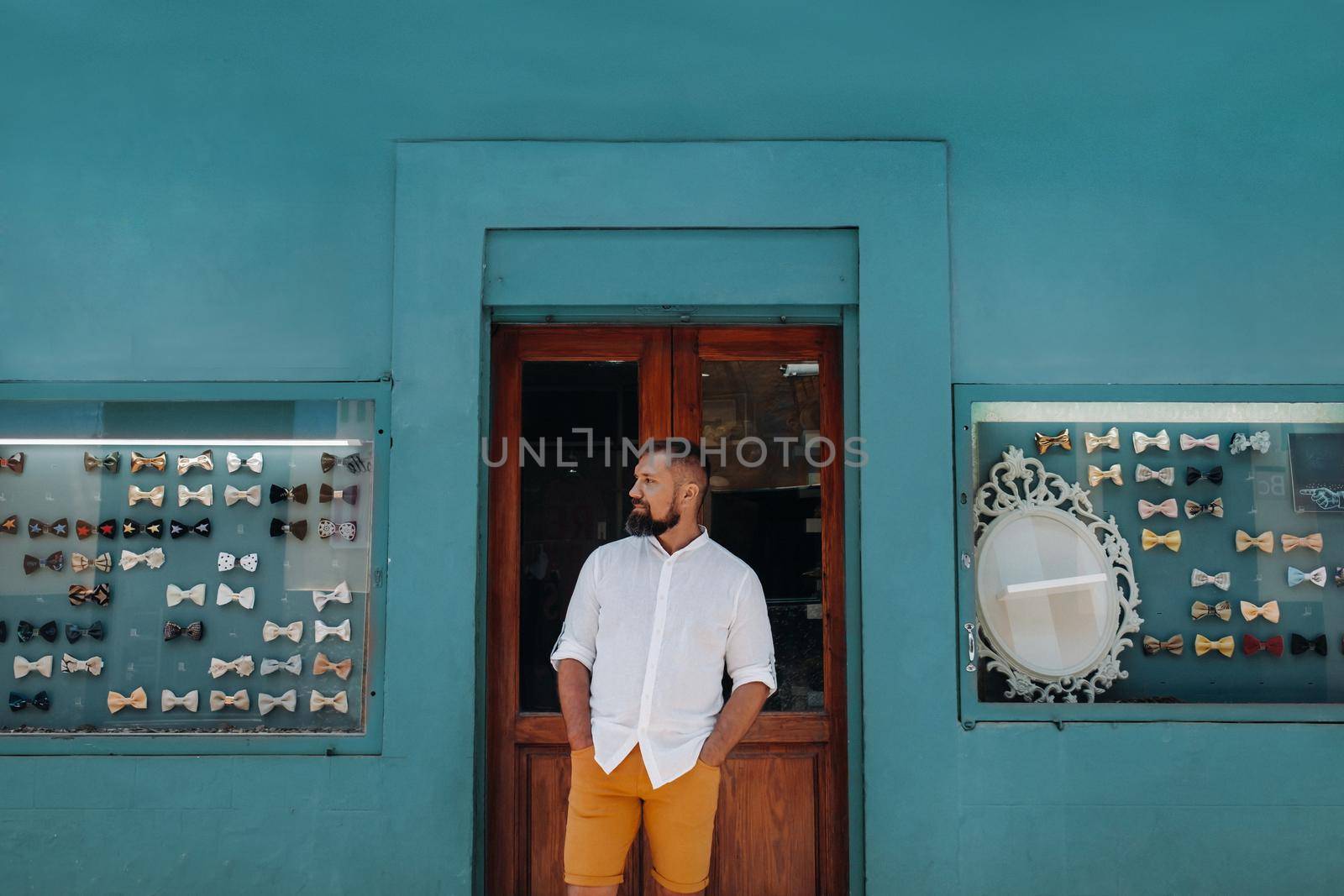 A man in the Old town of La Laguna on the island of Tenerife on a Sunny day against the background of a counter with butterflies on costumes.Butterflies for men's costumes in the Canary Islands.Spain
