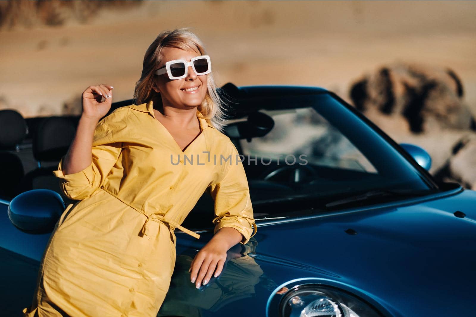 A life Portrait of a young woman enjoying a ride through a deserted valley, getting out of a convertible on the side of the road.Canary islands.Tenerife by Lobachad