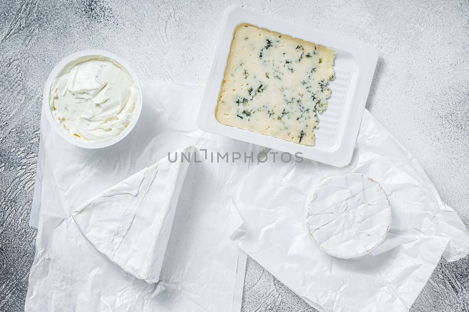 Variety of cheese kinds on kitchen table, brie, Camembert, Gorgonzola and blue creamy cheese. White background. Top view by Composter
