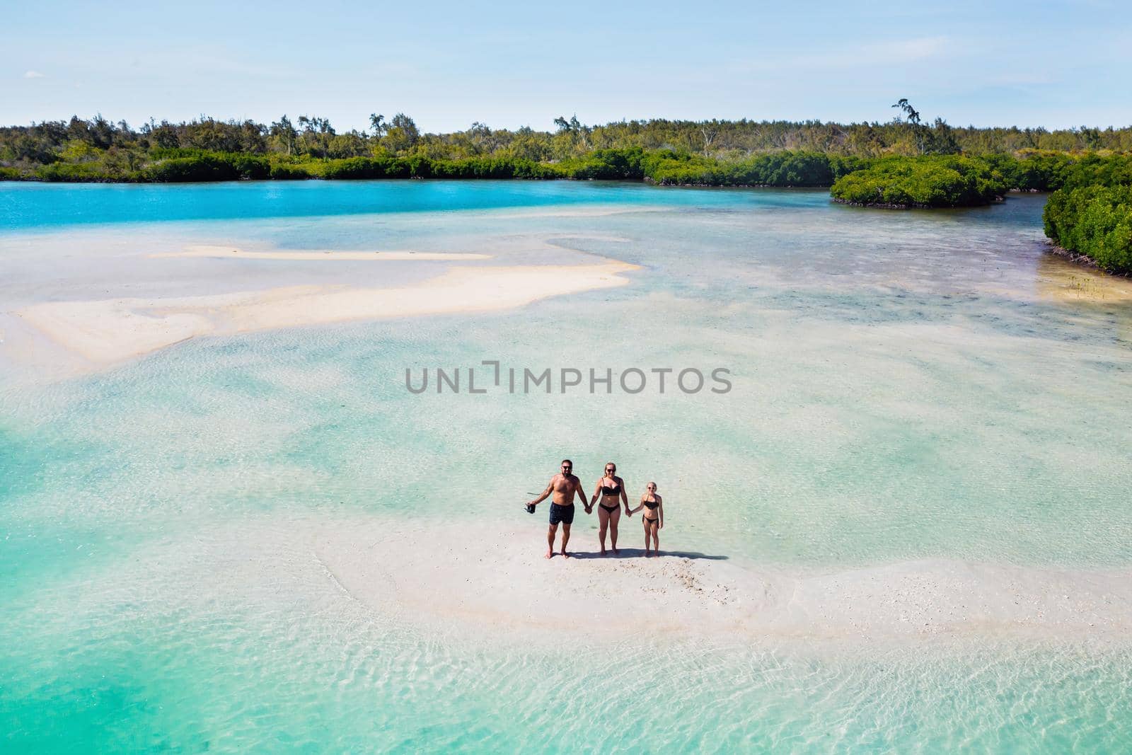 A young beautiful family with a child on the tropical island of Mauritius.The family stands on a small island in the Indian ocean.Mauritius island.