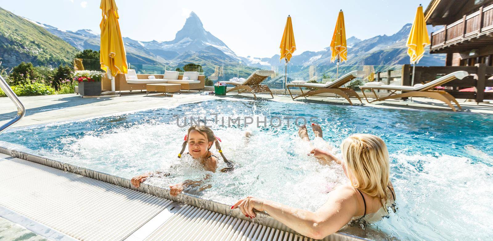 Mother And Child Girl Swimming In Pool In Mountains