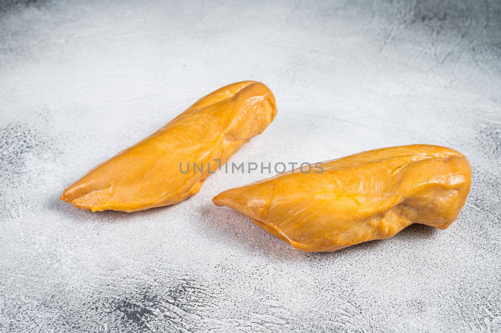 Smoked chicken breast fillet meat delicacy. White background. Top view.