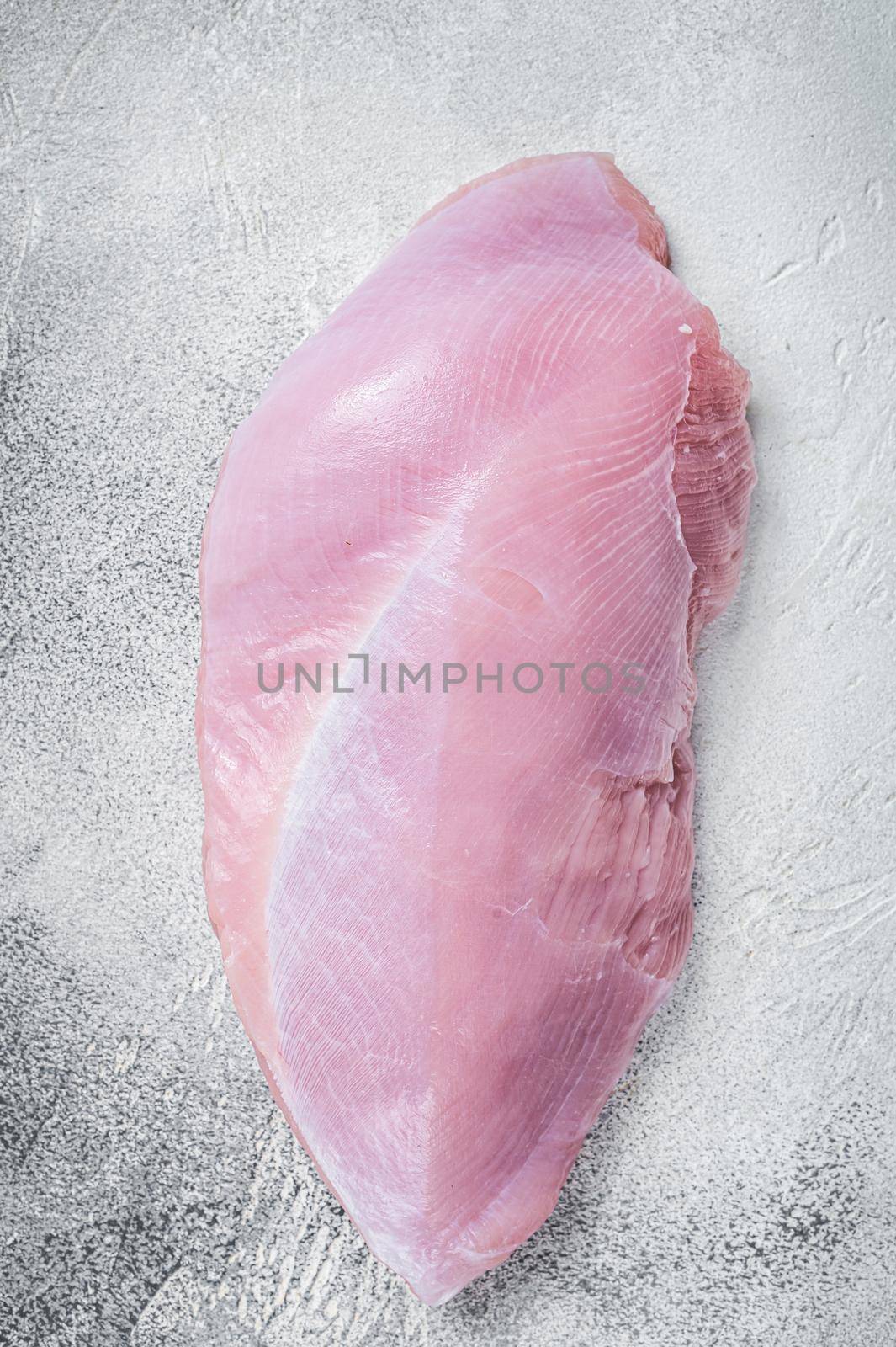 Raw whole big turkey breast fillet. White background. Top View by Composter