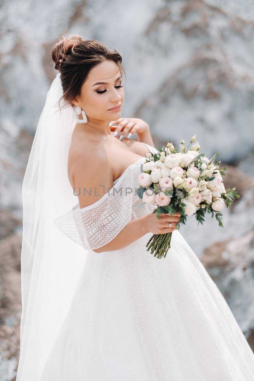 Beautiful bride in a wedding dress with a bouquet on the top of the salt mountains. A stunning young bride with curly hair . Wedding day. . Beautiful portrait of the bride without the groom