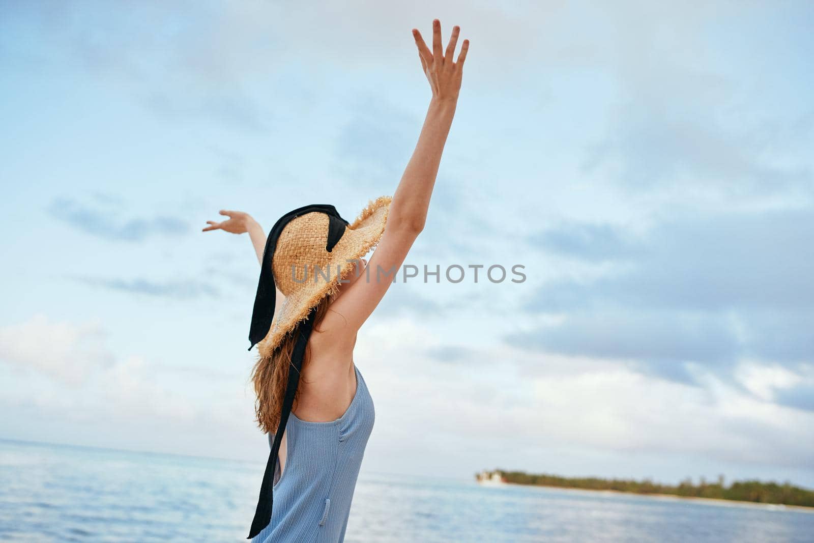 cheerful woman in a beach hat by the ocean island summer. High quality photo