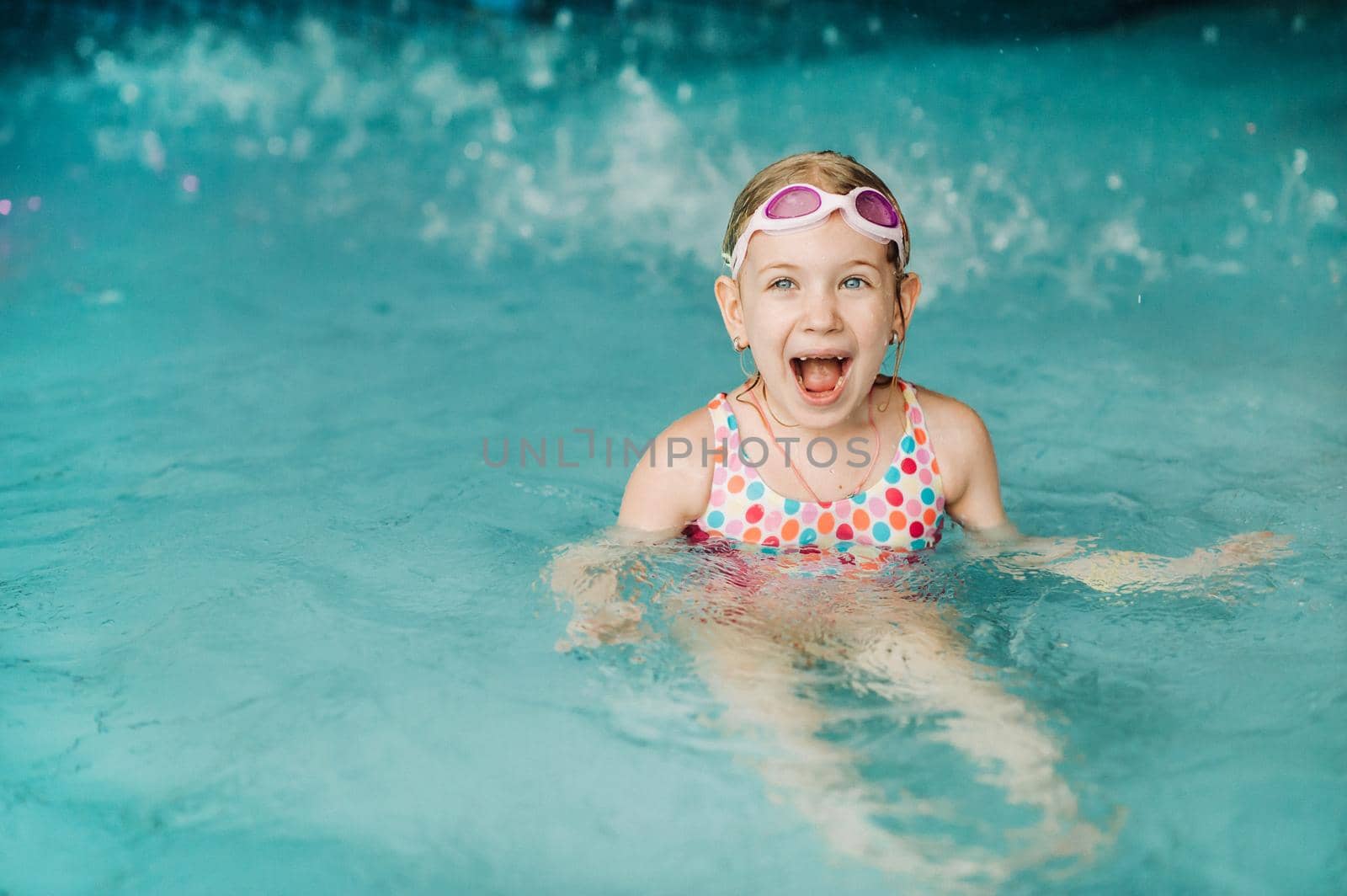 Kids play in aqua park. Children at water playground of tropical amusement park. Little girl at swimming pool. Child playing at water. Swim wear for young kid