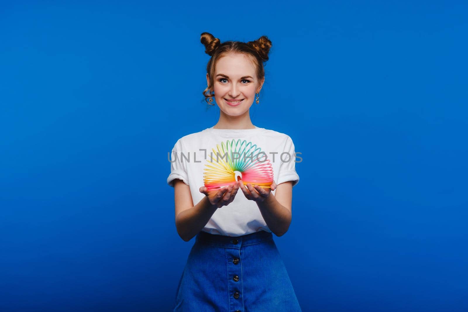 alluring young woman in white t-shirt and blue jeans posing over white background