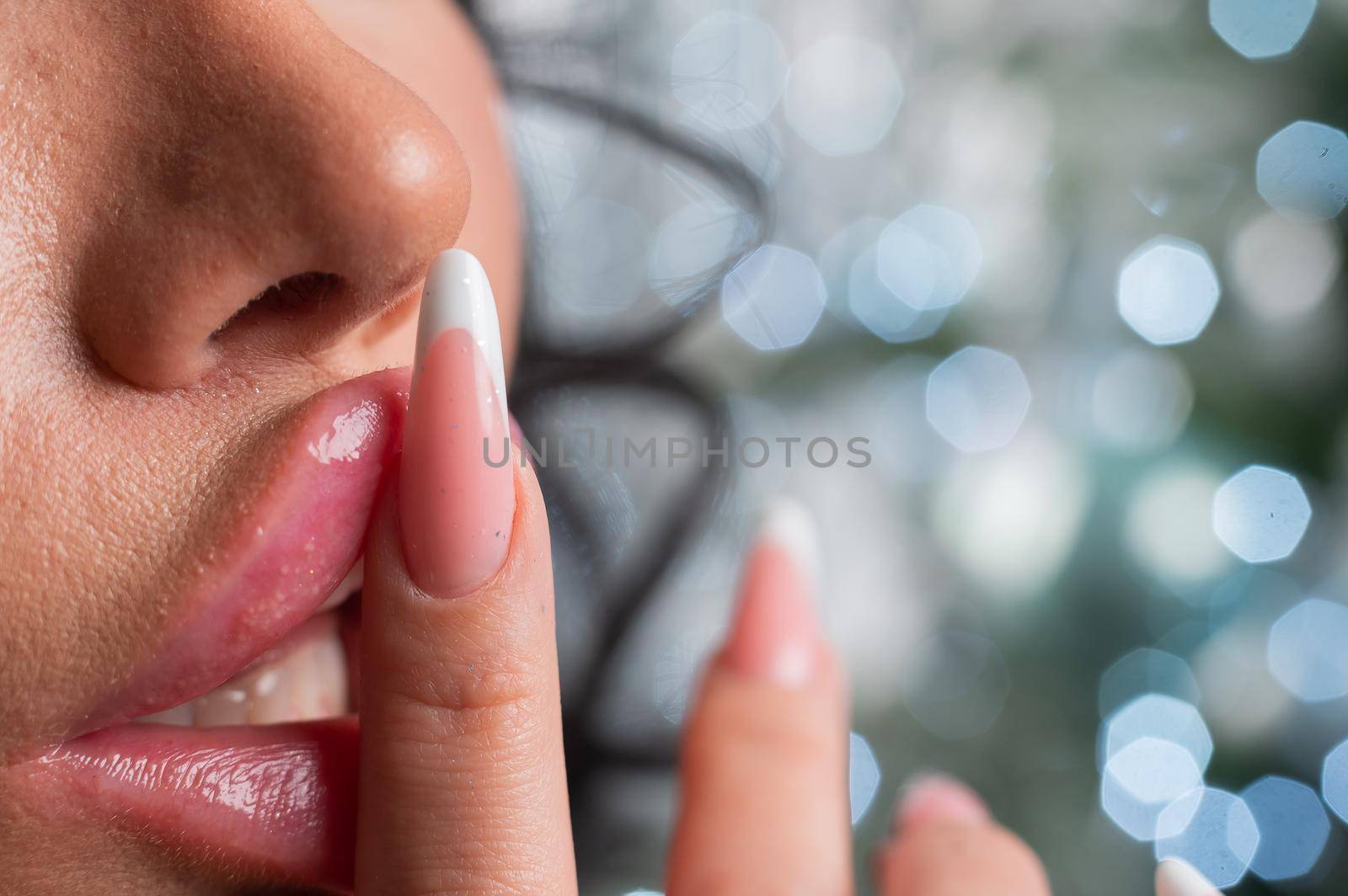 Close-up of large plump female lips against a background of christmas decorations