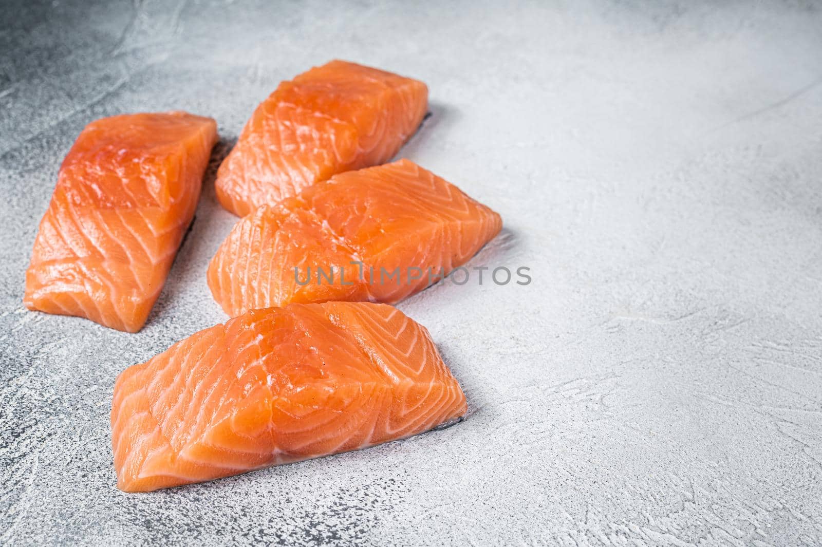 Raw salmon fillet steak on kitchen table. White background. Top view. Copy space.