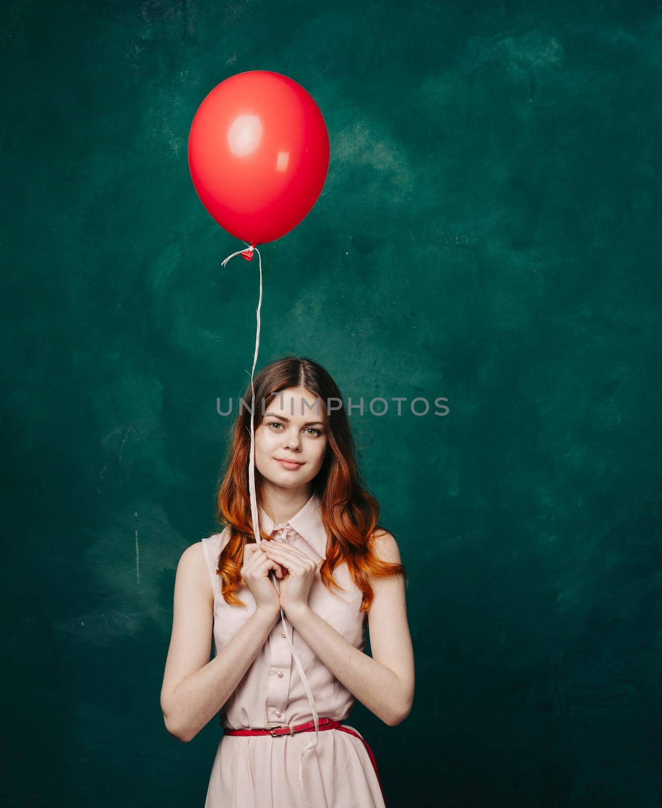 pretty woman in dress red balloon holiday green background. High quality photo
