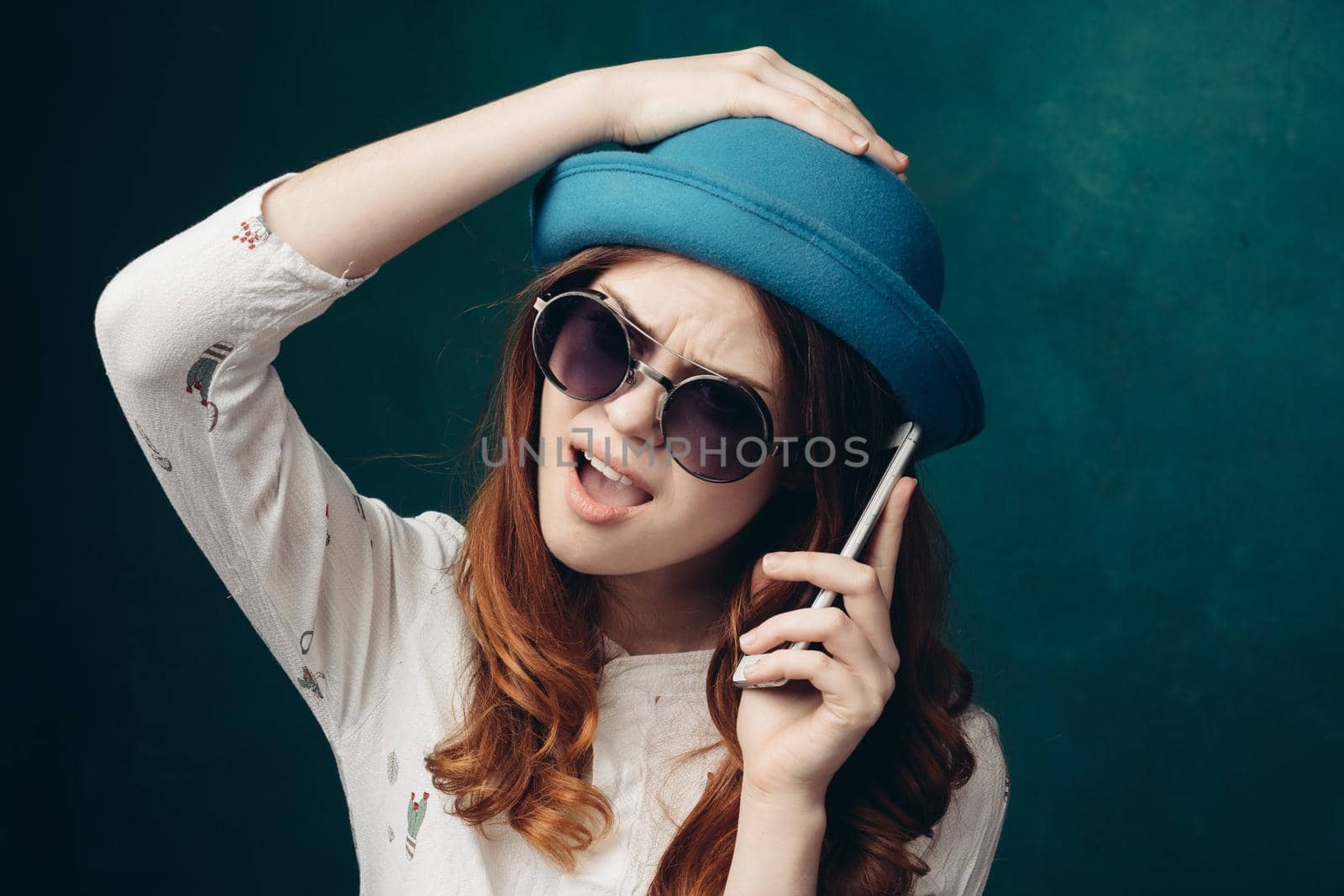 fashionable woman in blue hat with phone in hands communication technology. High quality photo