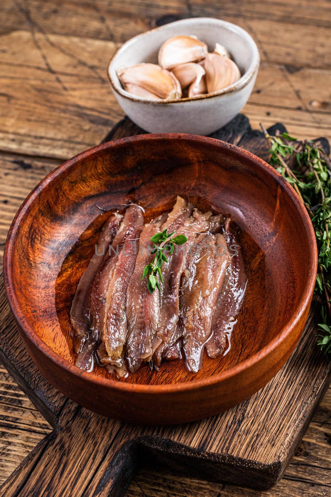 Canned Anchovies fish fillet in a wooden bowl. wooden background. Top view by Composter