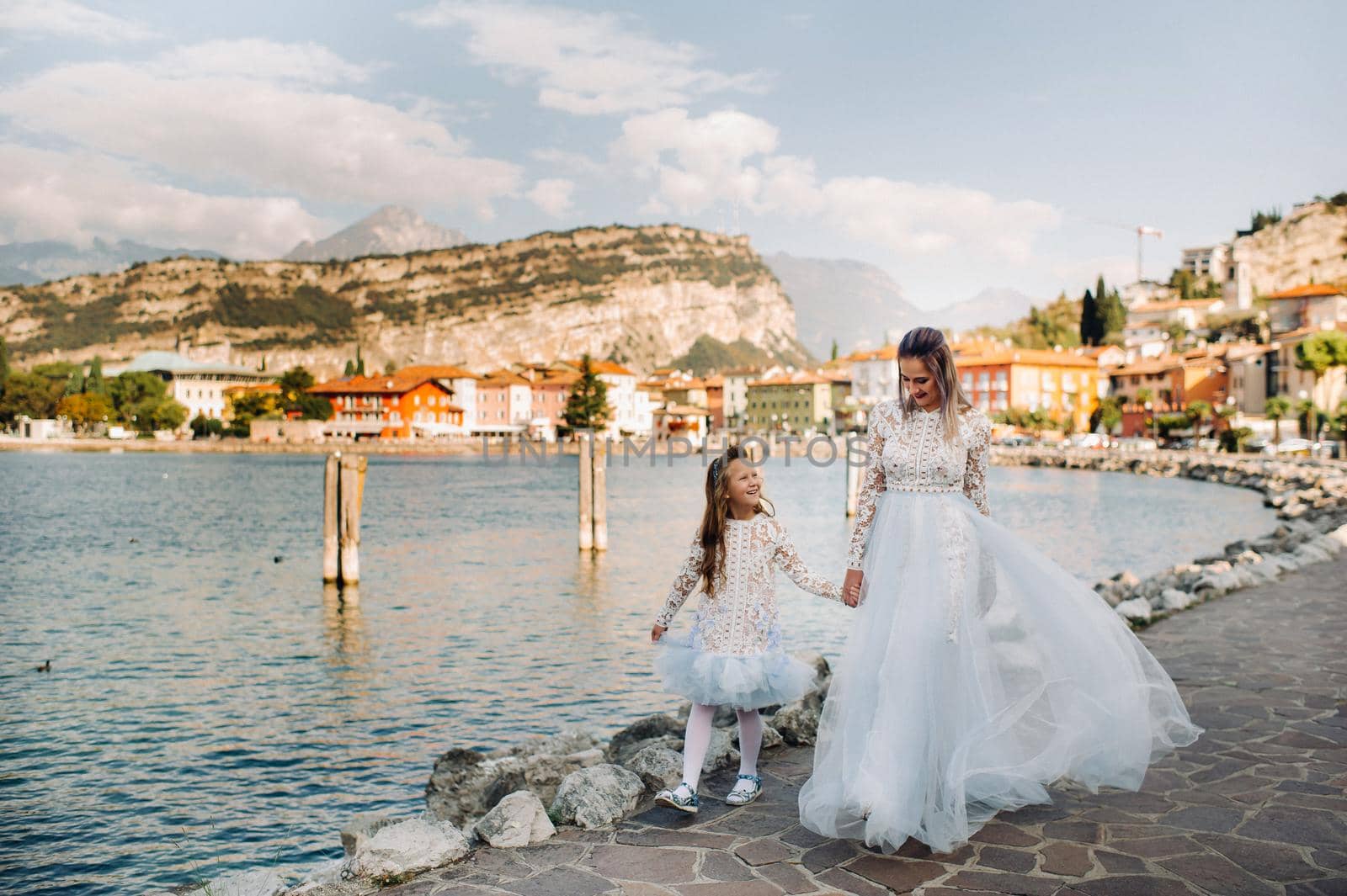 Italy, Lake Garda.Stylish Mother and daughter on the shores of lake Garda in Italy at the foot of the Alps. mother and daughter in Italy.