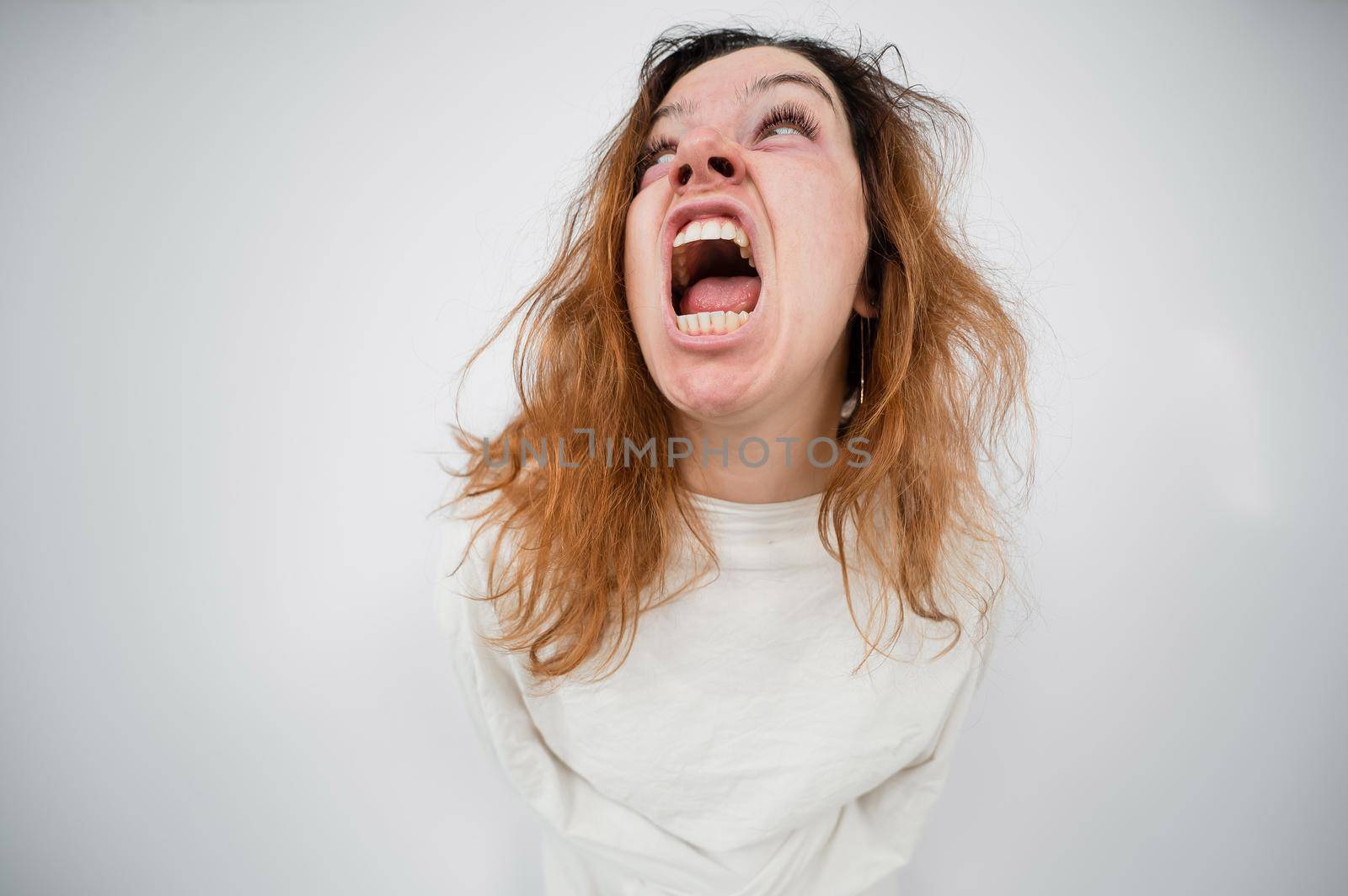 Close-up portrait of insane woman in straitjacket on white background