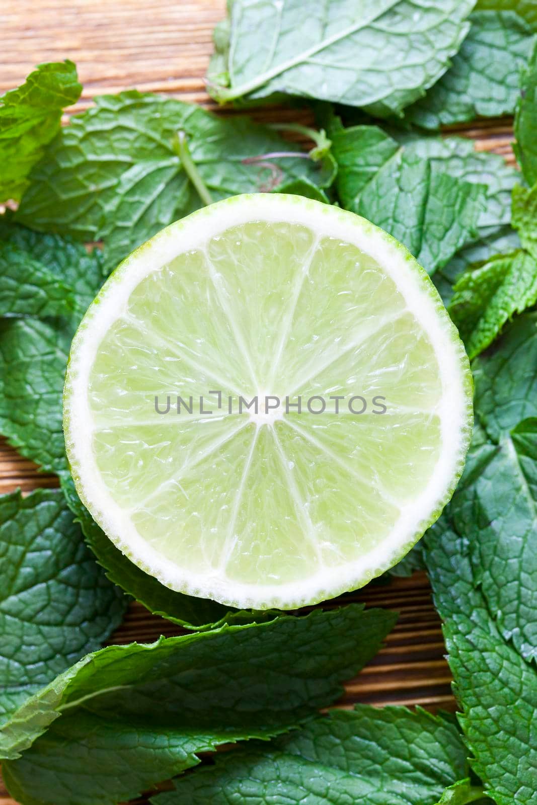 beautiful round lime slice, lying on the green fragrant leaves of mint leaves Preparing drinks, close-up on top