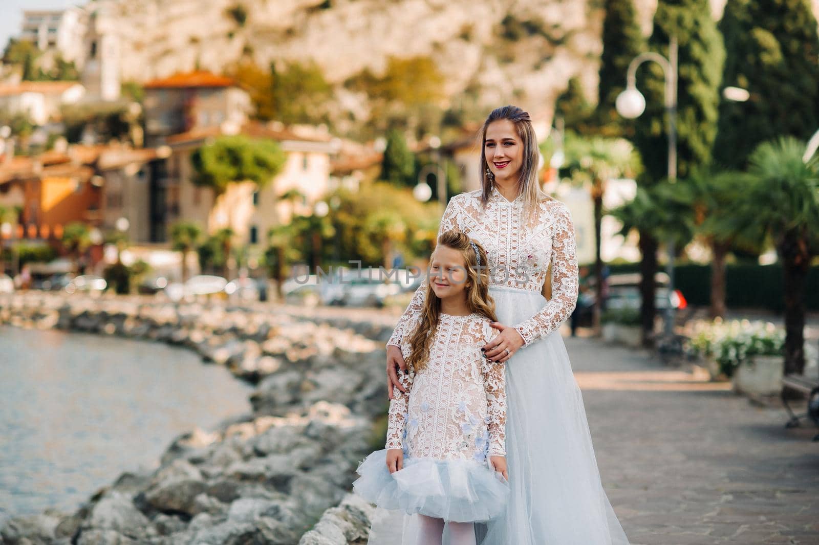 Italy, Lake Garda.Stylish Mother and daughter on the shores of lake Garda in Italy at the foot of the Alps. mother and daughter in Italy.