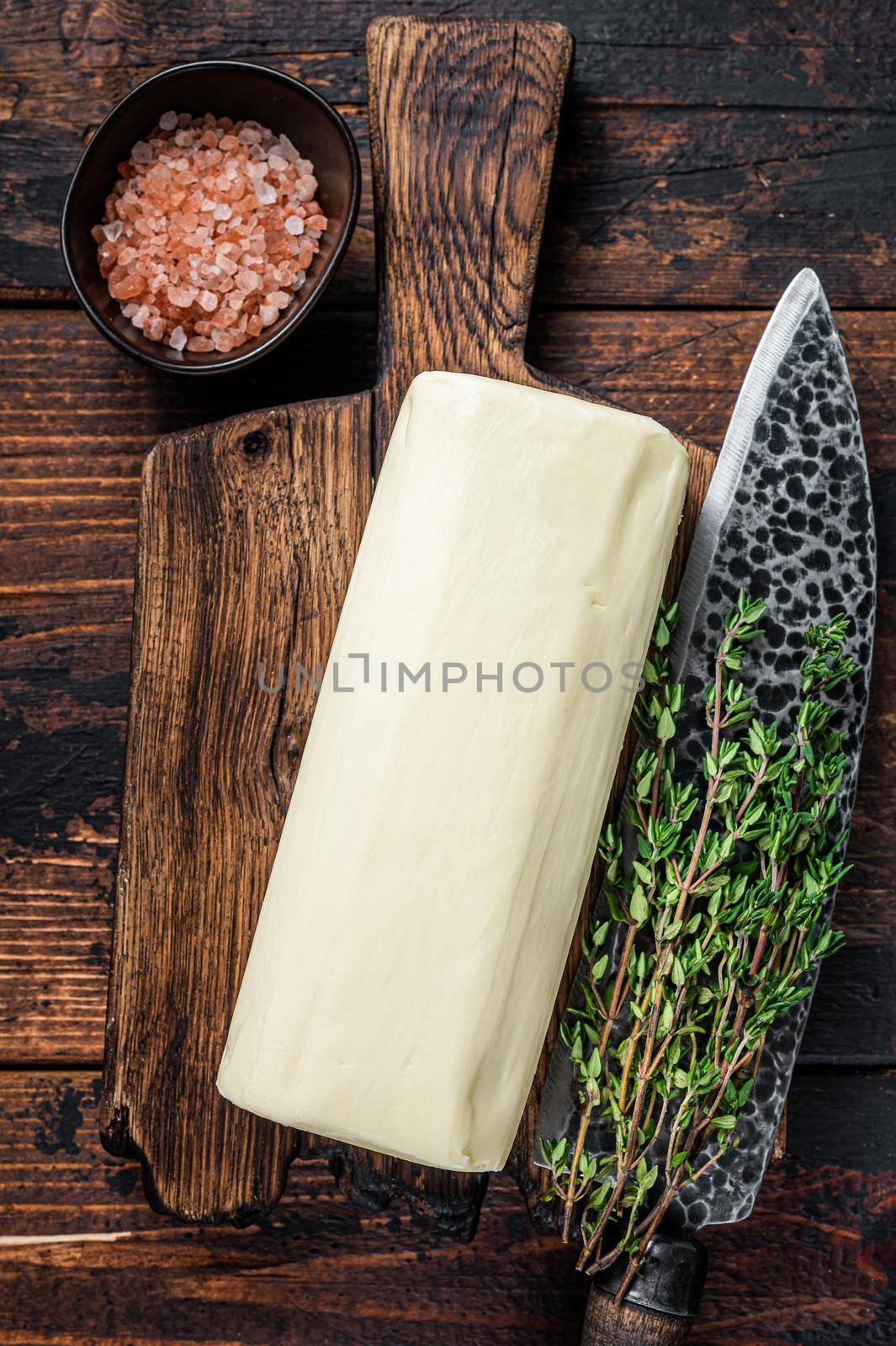 Butter Spread block on a wooden board. Dark wooden background. Top view by Composter