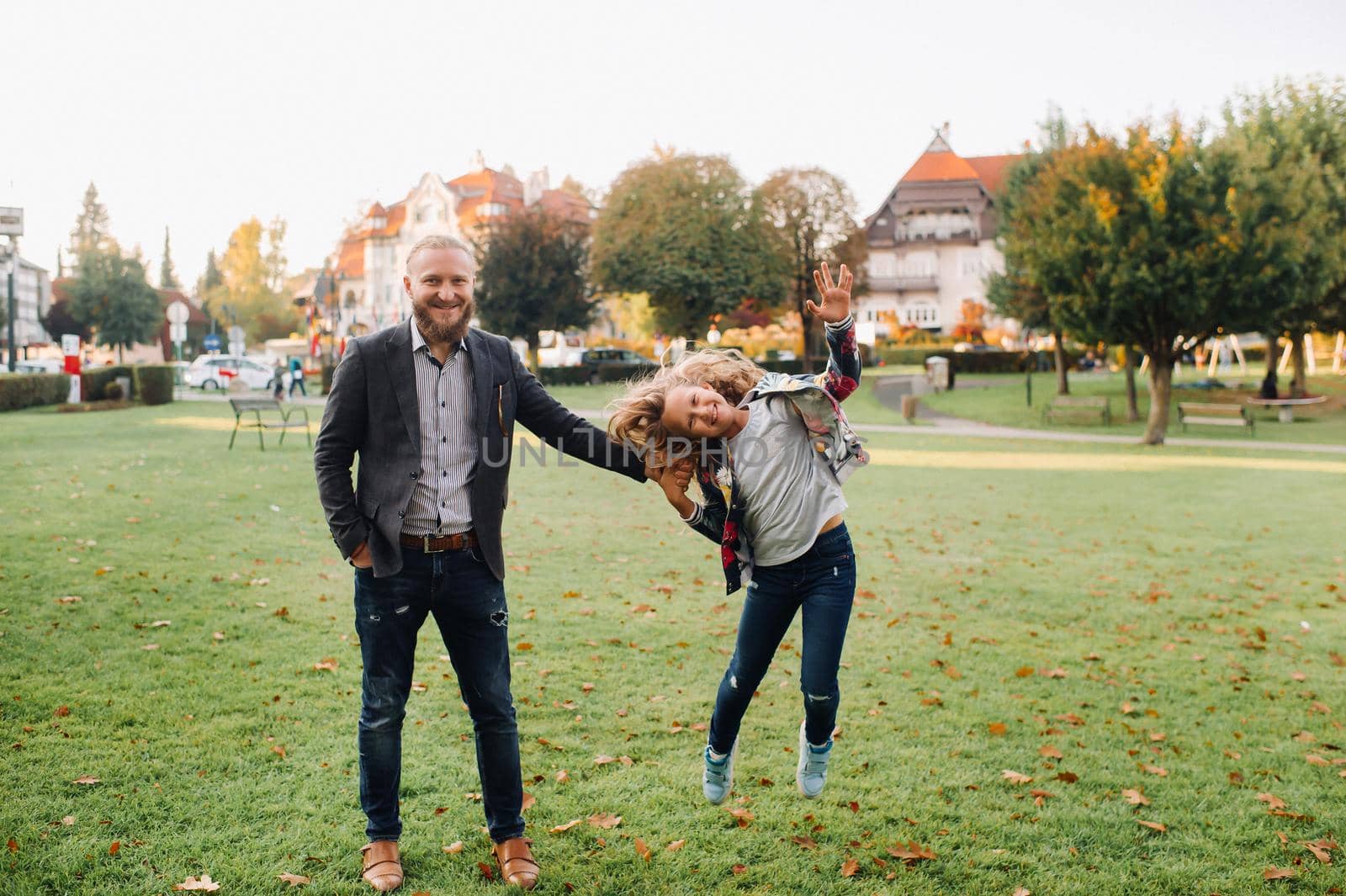 Father and daughter running on the grass in the old town of Austria.A family walks through a small town in Austria.Europe.Felden am Werten see by Lobachad