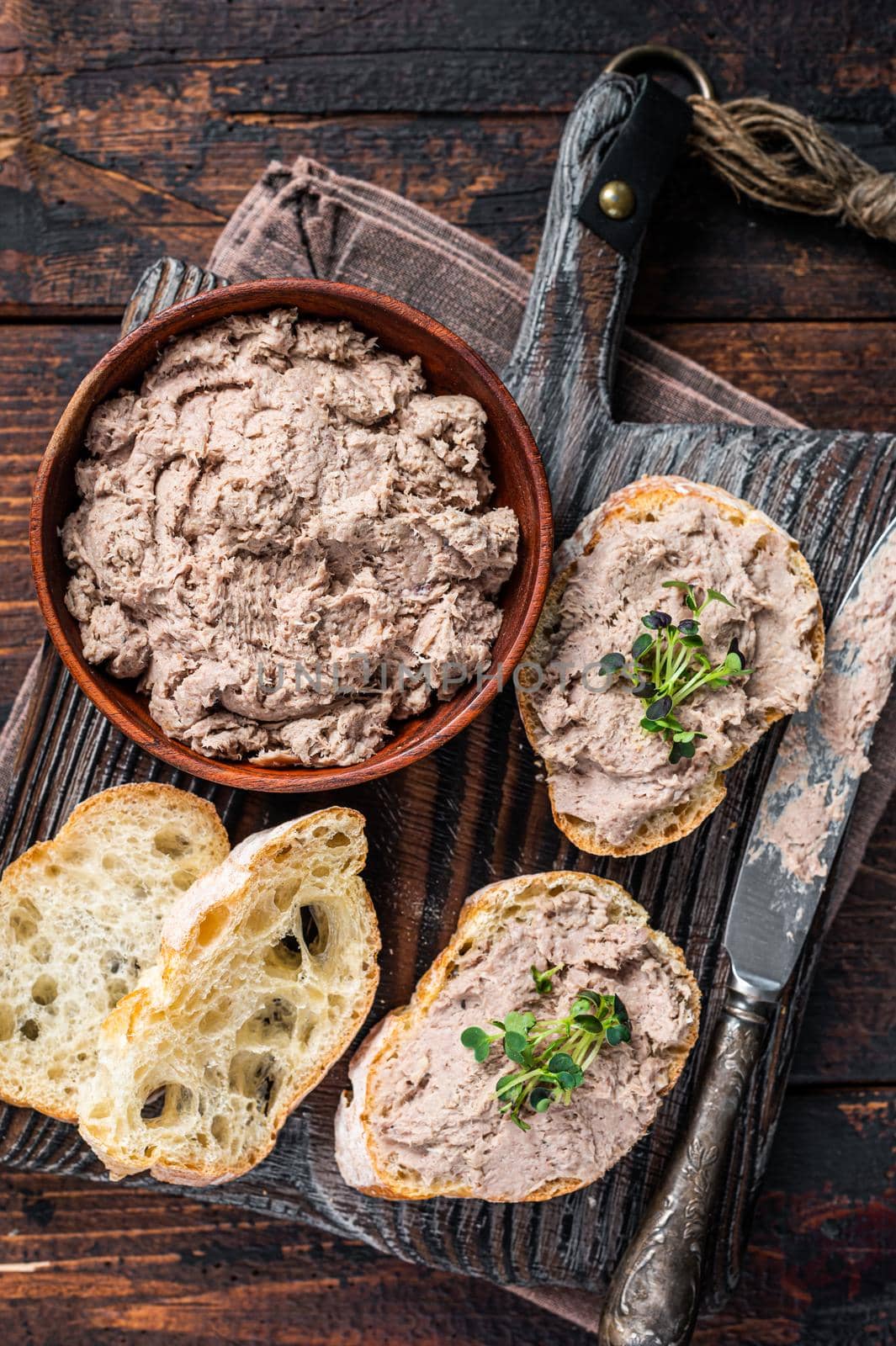 Toasts with Duck pate Rillettes de Canard on wooden board. Dark wooden background. Top View by Composter