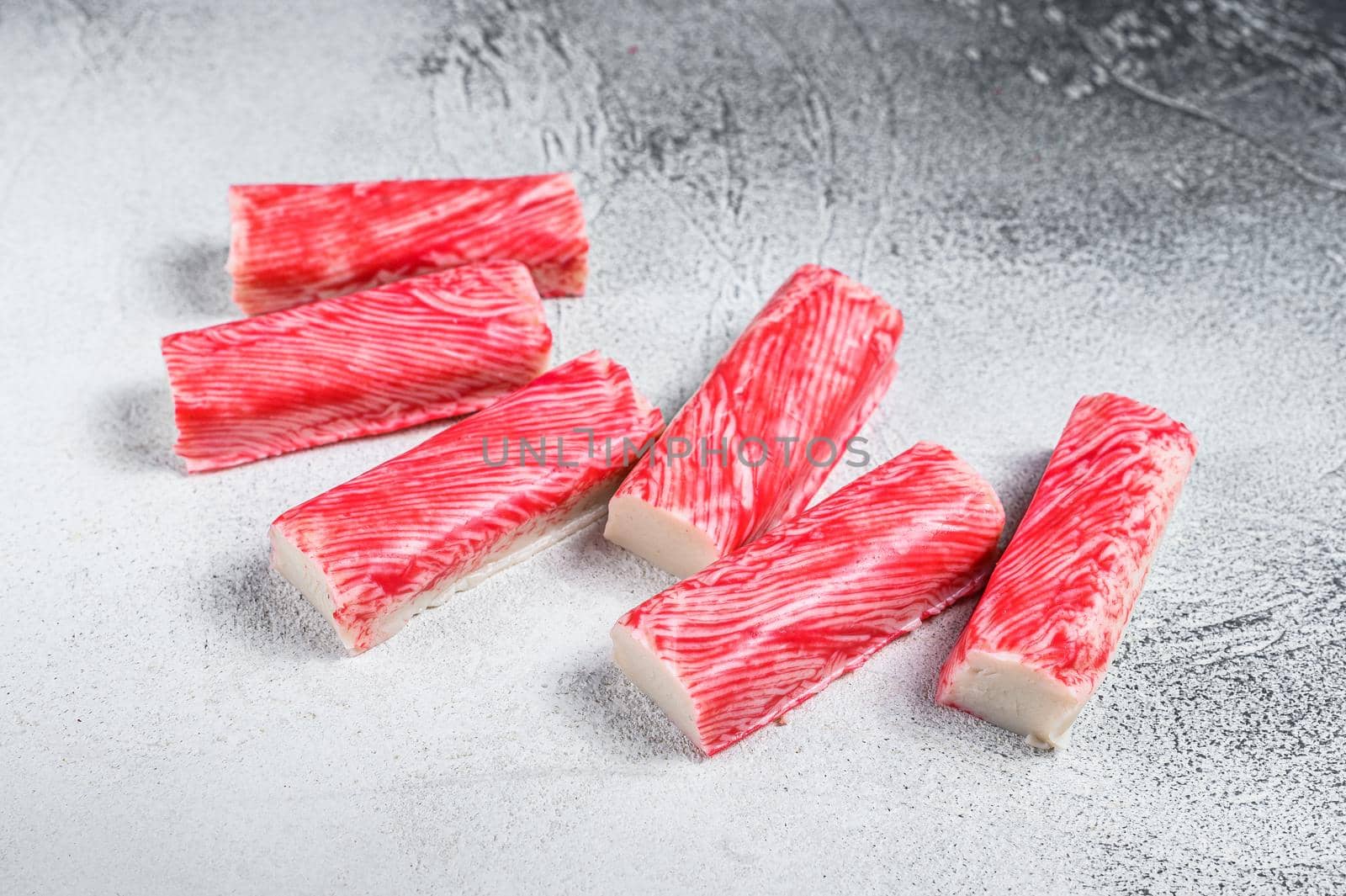 Crab surimi sticks on kitchen table. White background. Top view by Composter