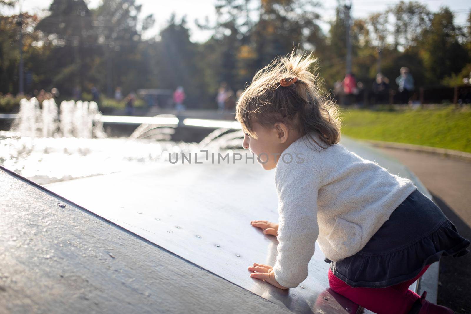 adorable toddler girl plays on a sunny fine day in the park. close up