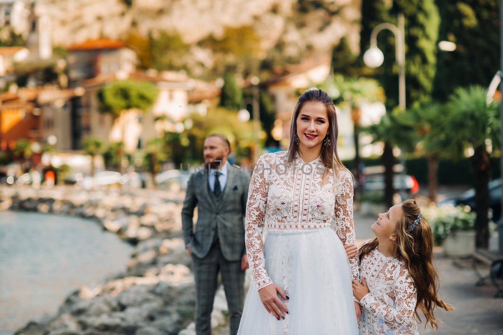 Italy, Lake Garda. Beautiful family on the shores of lake Garda in Italy at the foot of the Alps. Father, mother and daughter in Italy by Lobachad