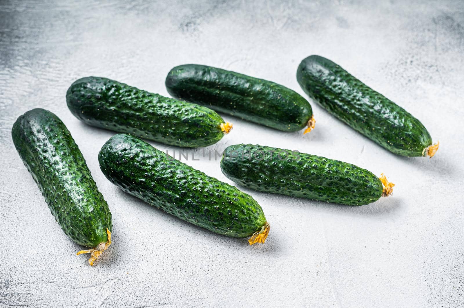 Organic Green Cucumbers on a kitchen table. White background. Top view by Composter