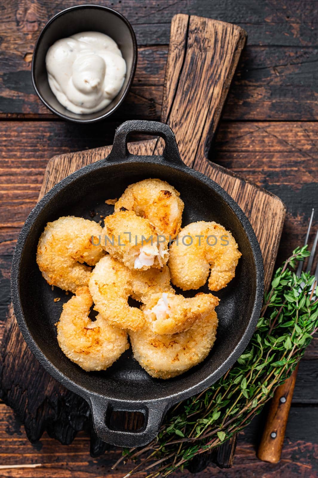 Fried Breaded Shrimps Prawns in a pan. Dark wooden background. Top view by Composter