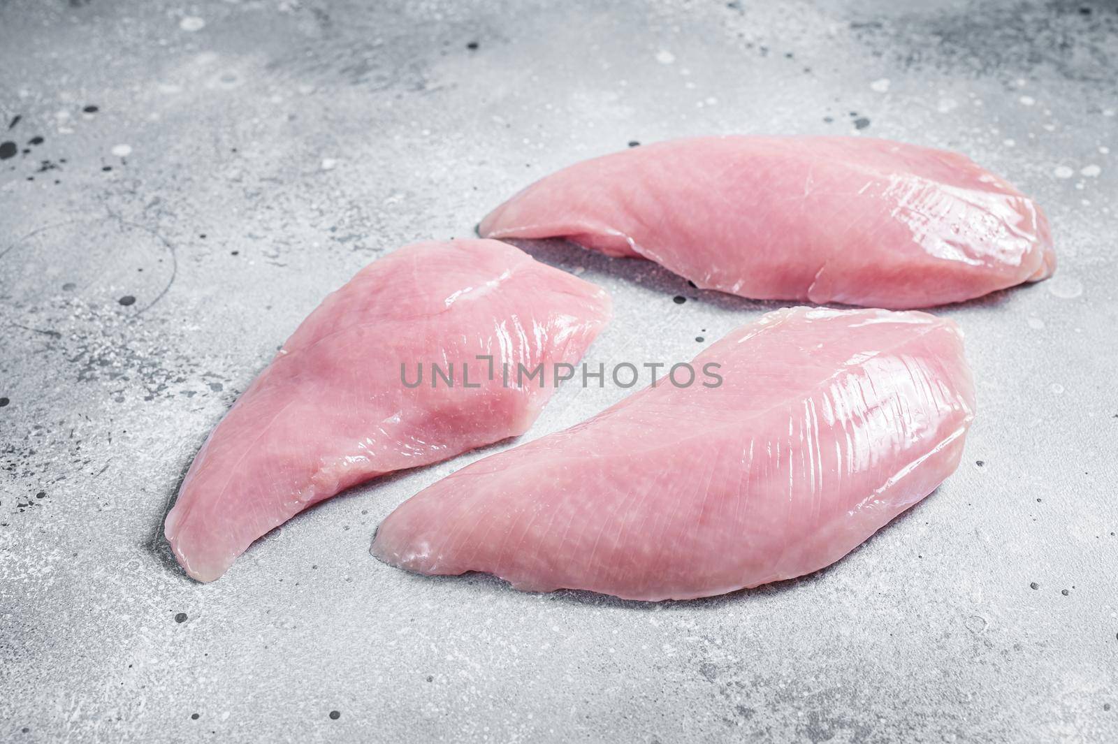 Raw Turkey Breasts fillet steaks. Gray background. Top view by Composter