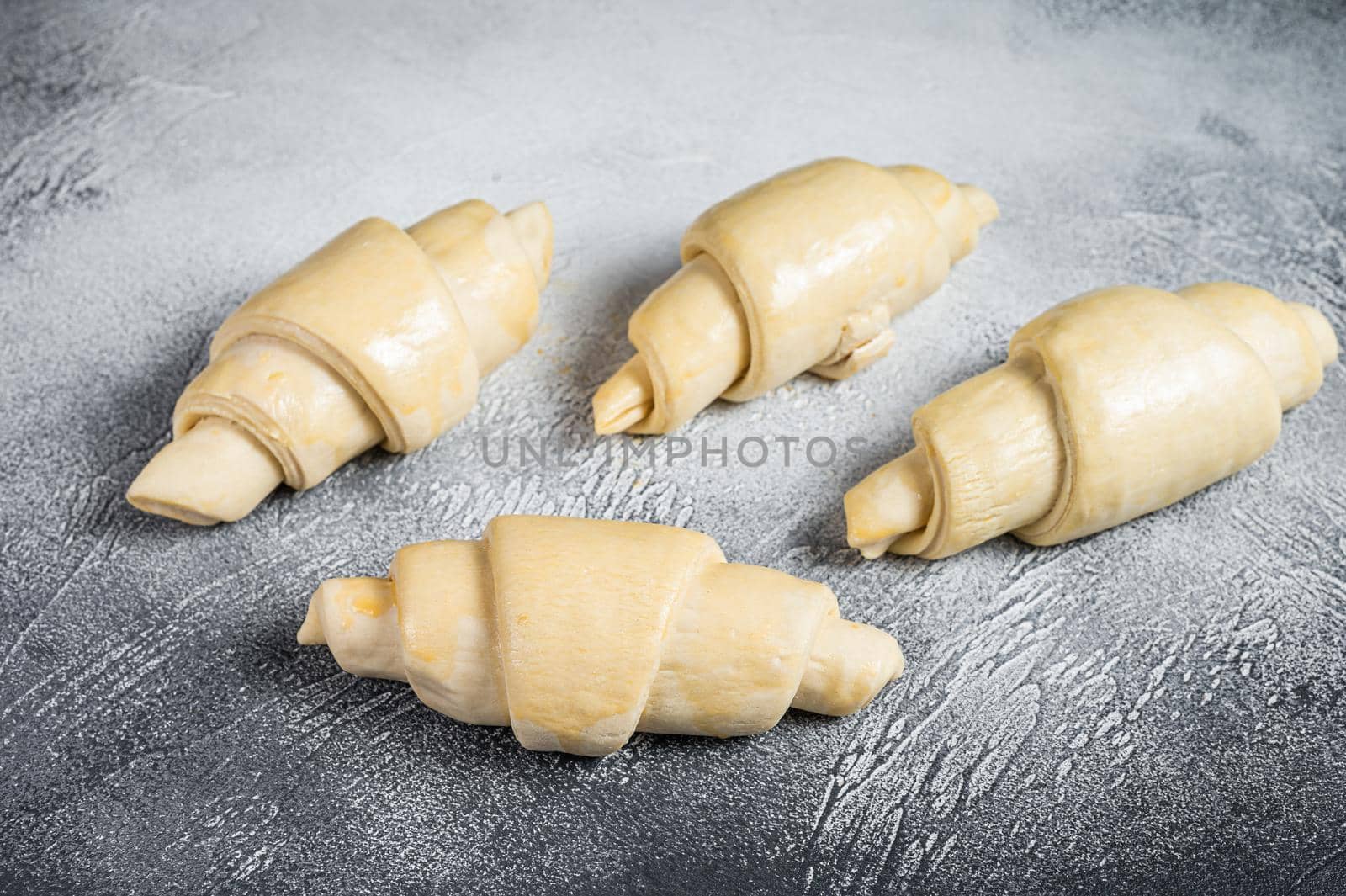 Raw unbaked croissant on kitchen table. White background. Top view by Composter