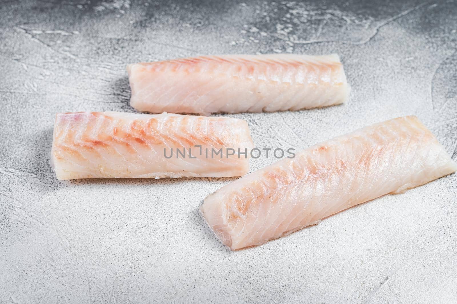 Raw Norwegian cod fish fillet on kitchen table. White background. Top view by Composter