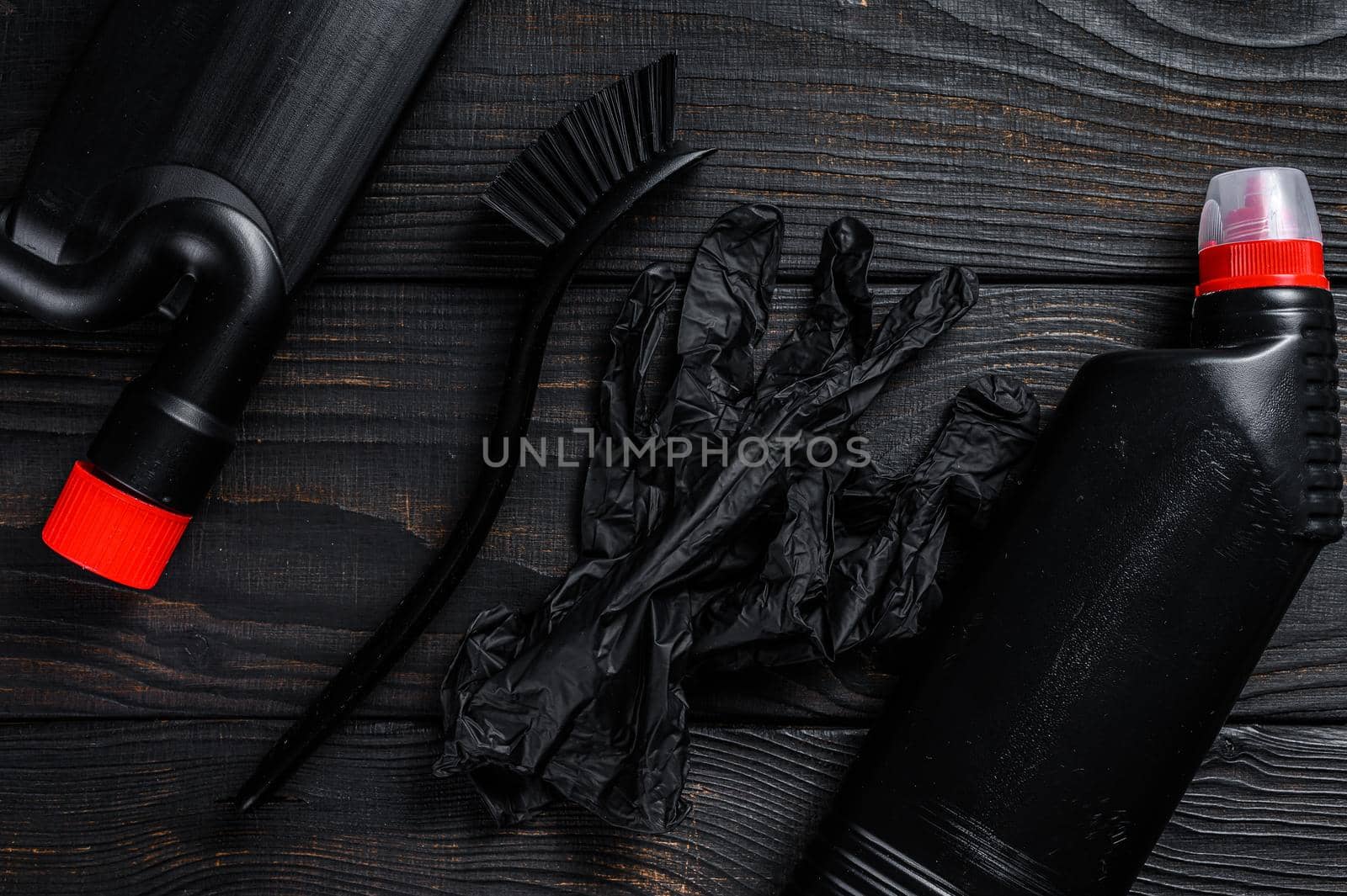 Black style Home cleaning service concept with supplies. Black wooden background. Top view.