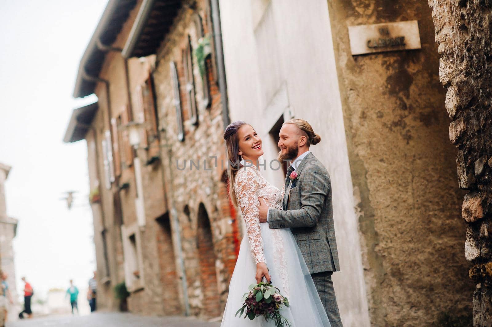 Beautiful family with walks in the old town of Sirmione in Italy.A couple strolling through old Italy.